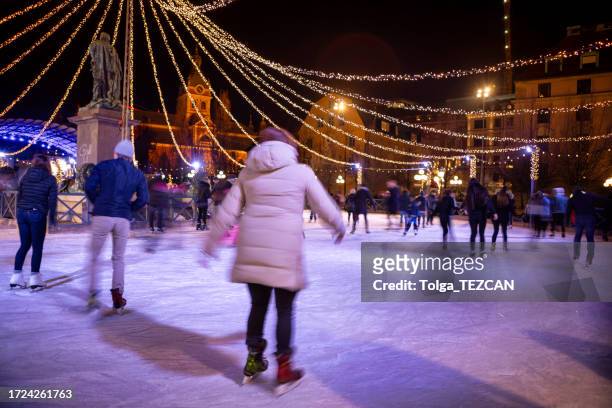 people skating in the park - dark ice rink stock pictures, royalty-free photos & images