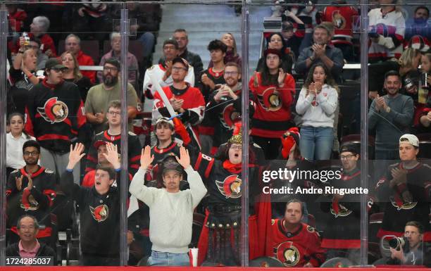 Fans of the Ottawa Senators cheer after their teams' 5-2 win against the Philadelphia Flyers at Canadian Tire Centre on October 14, 2023 in Ottawa,...