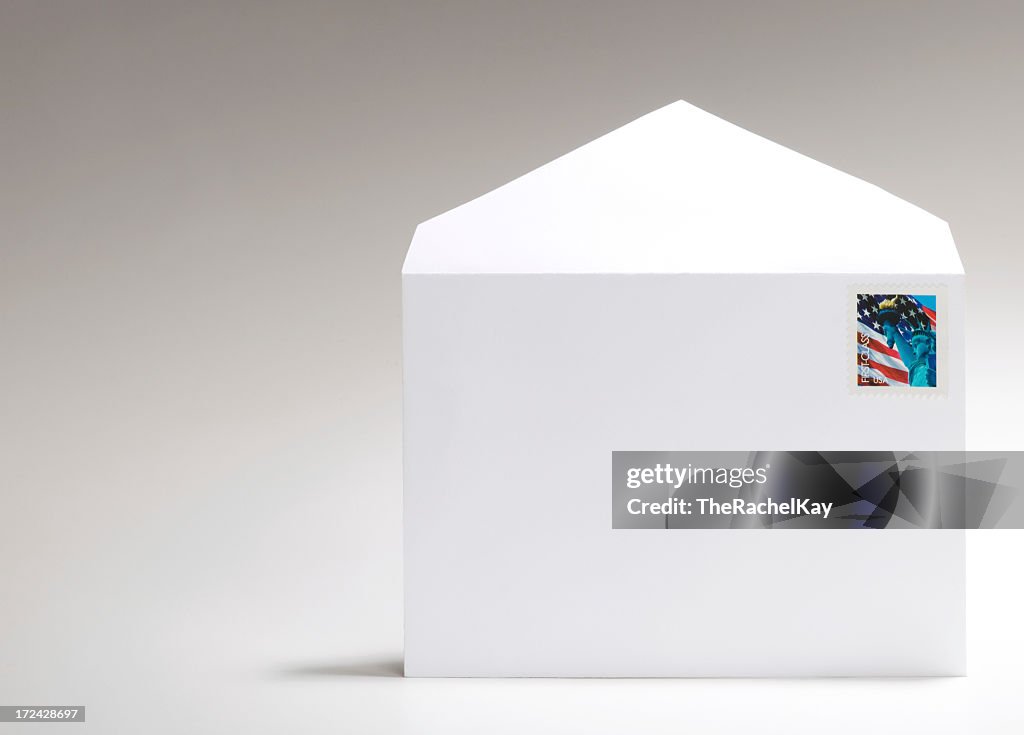 Blank, white envelope with American flag stamp on white