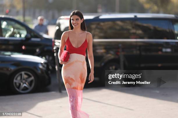 Sara Sampaio is seen wearing patterned strap dress in red and orange print, red handbag and silver creoles during the Stella McCartney Show...