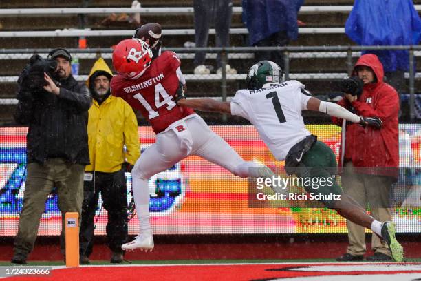 Wide receiver Isaiah Washington of the Rutgers Scarlet Knights catches a pass for a touchdown as defensive back Jaden Mangham of the Michigan State...