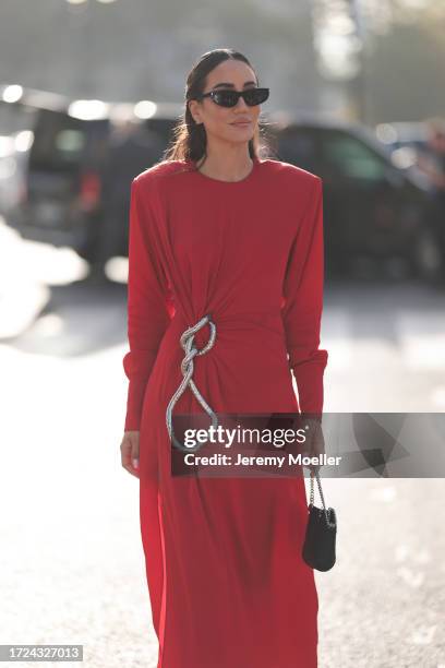 Tamara Kalinic is seen wearing long red dress, shoulder pads with side ruffles, silver chain and black leather handbag during the Stella McCartney...