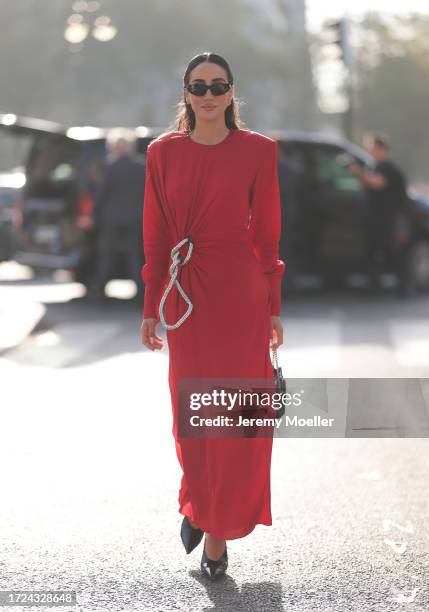 Tamara Kalinic is seen wearing long red dress, shoulder pads with side ruffles, silver chain and black leather handbag during the Stella McCartney...