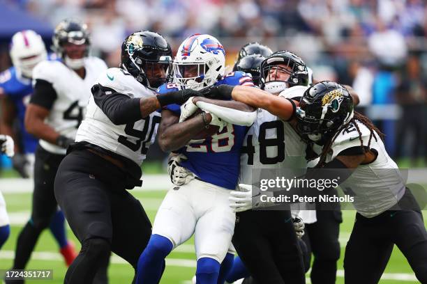 Latavius Murray of the Buffalo Bills is tackled by Angelo Blackson and Chad Muma of the Jacksonville Jaguars in the second Quarter during the NFL...