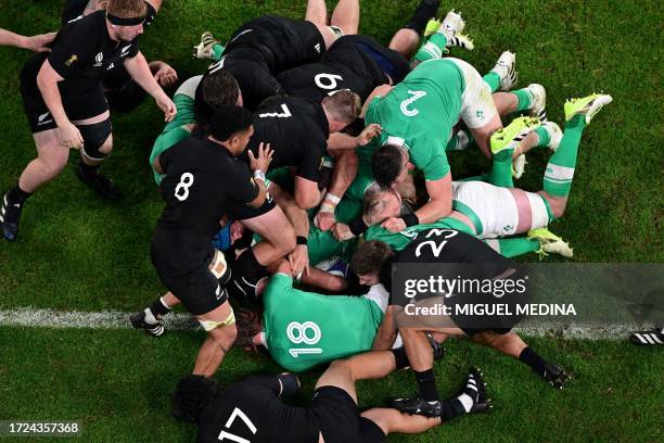 Players compete for the ball in a ruck during the France 2023 Rugby World Cup quarter-final match between Ireland and New Zealand at the Stade de...