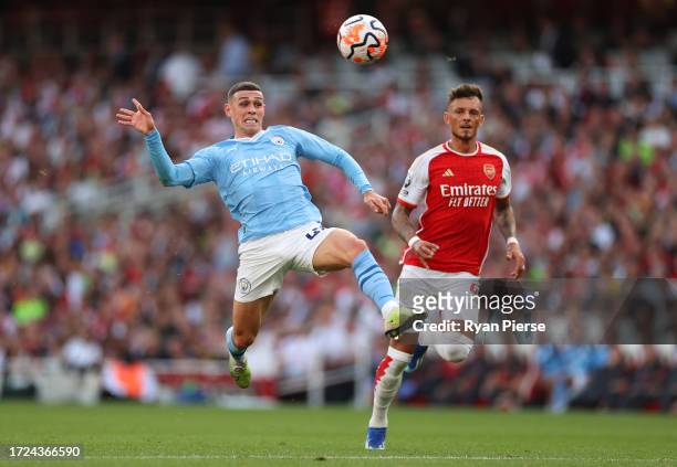 Phil Foden of Manchester City controls the ball whilst under pressure from Ben White of Arsenal during the Premier League match between Arsenal FC...