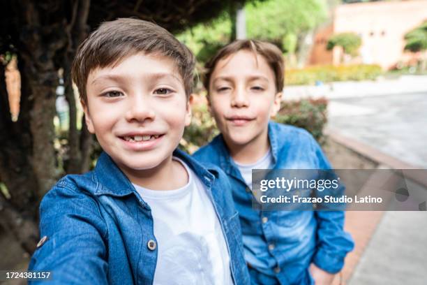 twin brothers taking a selfie outdoors - camera point of view - cousin stock pictures, royalty-free photos & images