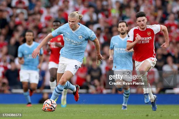 Erling Haaland of Manchester City runs with the ball whilst under pressure from Declan Rice of Arsenal during the Premier League match between...