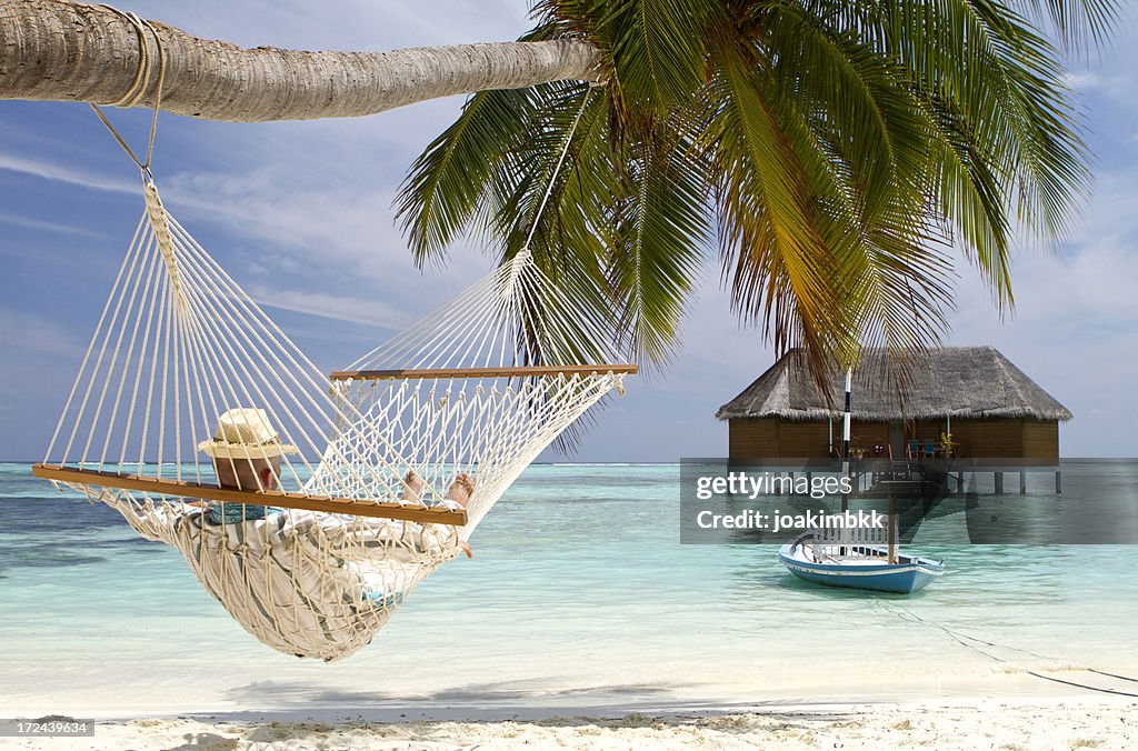 Young adult in hammock contemplating the sea view