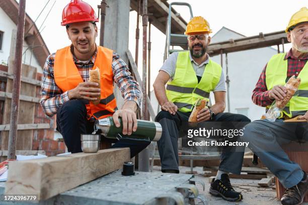 male caucasian architect, building contractor and engineer, having an lunch break on a construction site - refreshment break stock pictures, royalty-free photos & images