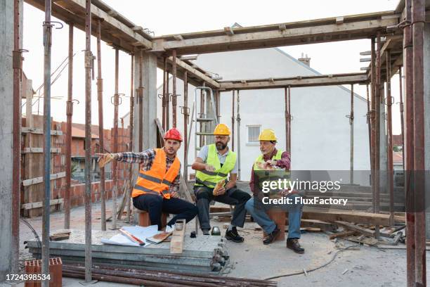 caucasian architect, building contractor and engineer, talking during an lunch break on a construction site - lunch break stock pictures, royalty-free photos & images
