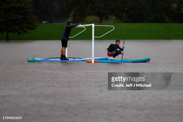 Paddle boarders are seen on a flooded football pitch in the North Inch area on October 08, 2023 in Perth, Scotland. The Scottish Environment...