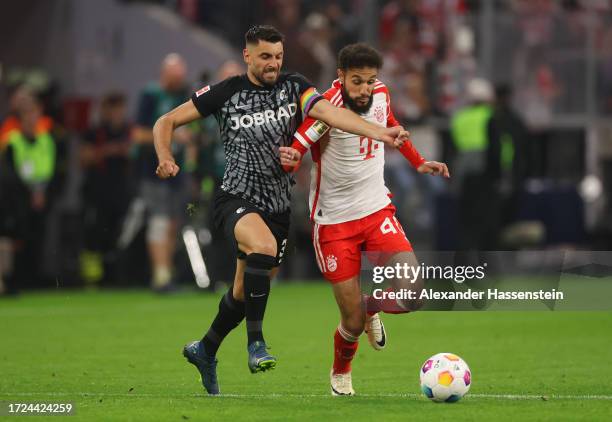 Vincenzo Grifo of Sport-Club Freiburg battles for possession with Noussair Mazraoui of Bayern Munich during the Bundesliga match between FC Bayern...
