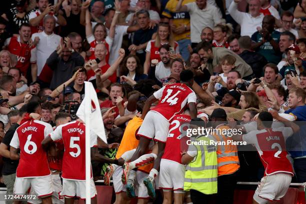 Gabriel Martinelli of Arsenal celebrates with team mates and fans after scoring their sides first goal during the Premier League match between...