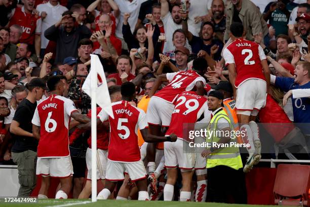 Gabriel Martinelli of Arsenal celebrates with team mates and fans after scoring their sides first goal during the Premier League match between...