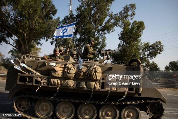 Israeli soldiers in an armoured personnel carrier head towards the southern border with the Gaza Strip on October 8, 2023 in Sderot, Israel. On...