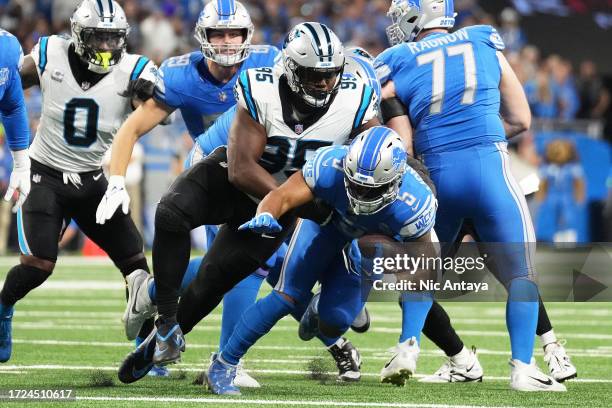 David Montgomery of the Detroit Lions runs with the ball while being tackled by Derrick Brown of the Carolina Panthers in the first quarter at Ford...