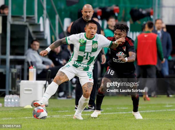 Hamzat Ojediran of DVSC challenges Cristian Ramirez of Ferencvarosi TC during the Hungarian OTP Bank Liga match between Ferencvarosi TC and DVSC at...