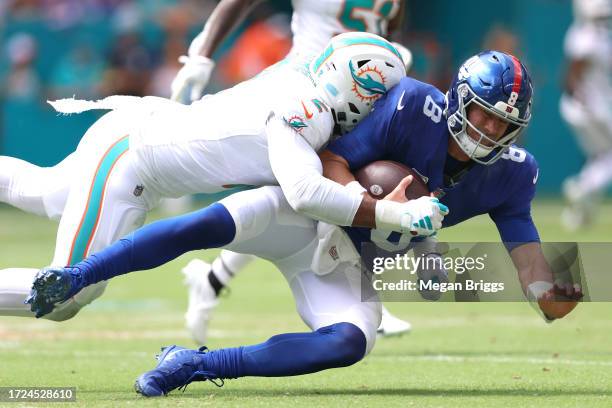 Bradley Chubb of the Miami Dolphins tackles Daniel Jones of the New York Giants during the first quarter at Hard Rock Stadium on October 08, 2023 in...