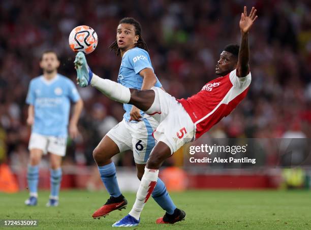 Thomas Partey of Arsenal controls the ball whilst under pressure from Nathan Ake of Manchester City during the Premier League match between Arsenal...