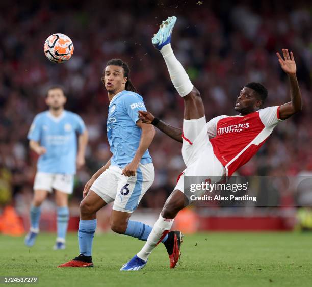 Thomas Partey of Arsenal controls the ball whilst under pressure from Nathan Ake of Manchester City during the Premier League match between Arsenal...