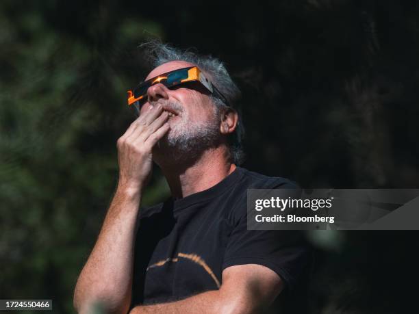 Spectator wears solar viewing glasses during a solar eclipse in Driftwood, Texas, US, on Saturday, Oct. 14, 2023. US grid operators are set to face...