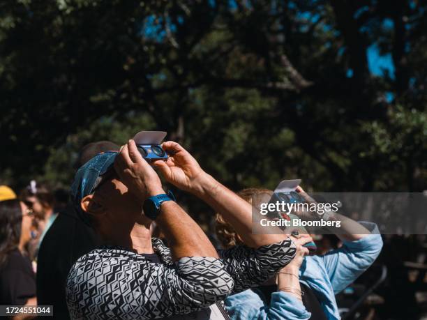 Spectators wear solar viewing glasses during a solar eclipse in Driftwood, Texas, US, on Saturday, Oct. 14, 2023. US grid operators are set to face...