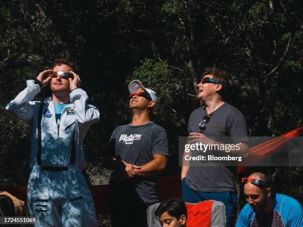 Spectators wear solar viewing glasses during a solar eclipse in Driftwood, Texas, US, on Saturday, Oct. 14, 2023. US grid operators are set to face...