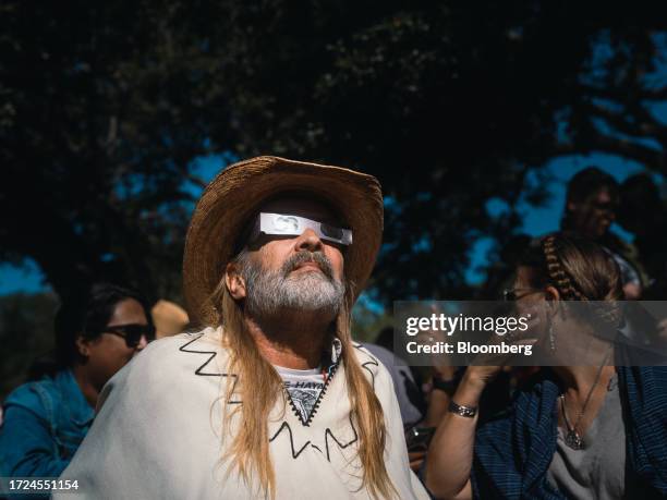 Spectator wears solar viewing glasses during a solar eclipse in Driftwood, Texas, US, on Saturday, Oct. 14, 2023. US grid operators are set to face...
