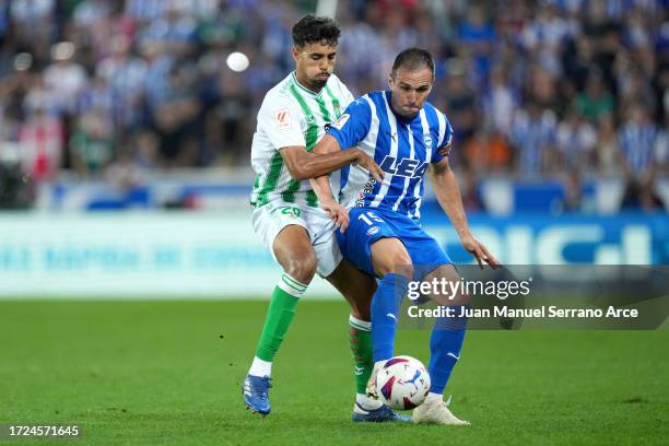 Kike of Deportivo Alaves is challenged by Chadi Riad of Real Betis during the LaLiga EA Sports match between Deportivo Alaves and Real Betis at...