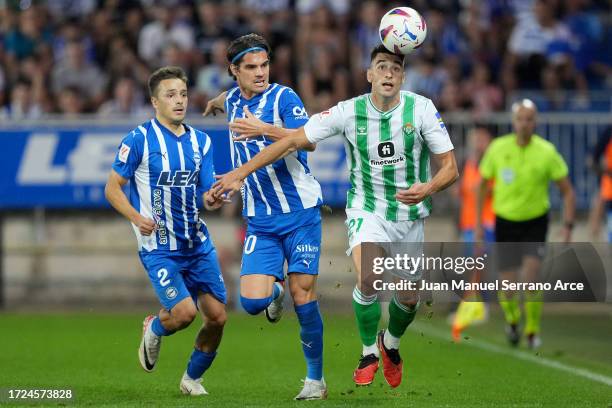 Marc Roca of Real Betis is challenged by Andoni Gorosabel and Ianis Hagi of Deportivo Alaves during the LaLiga EA Sports match between Deportivo...