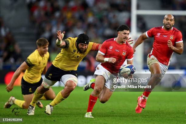 Patrick Pellegrini of Tonga breaks with the ball whilst under pressure from Damian Stratila of Romania during the Rugby World Cup France 2023 match...