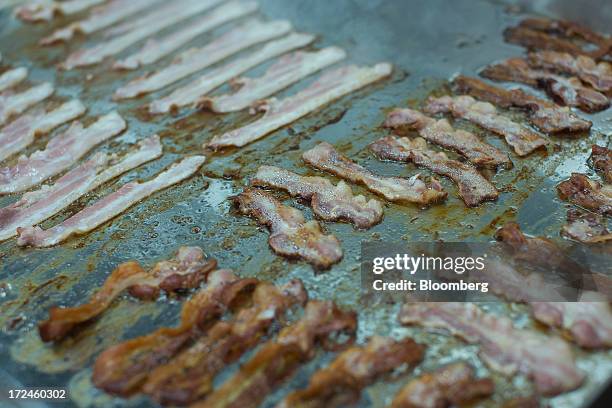 American streaky bacon is seen cooking on a griddle in the kitchen at the first U.K. Outlet of U.S. Burger restaurant chain Five Guys in London,...