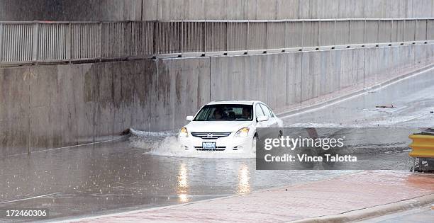 Drivers attempt to drive through flooded area on North Queen in Etobicoke.