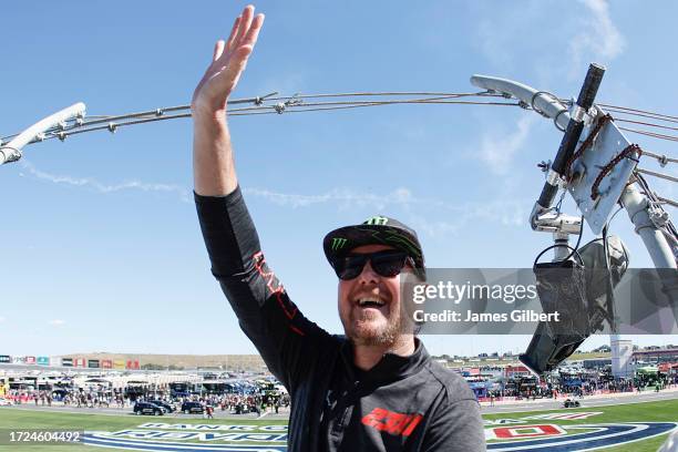 Honorary Starter, retired NASCAR driver and advisor to 23XI Racing, Kurt Busch waves to fans from the flagstand prior to the NASCAR Cup Series Bank...