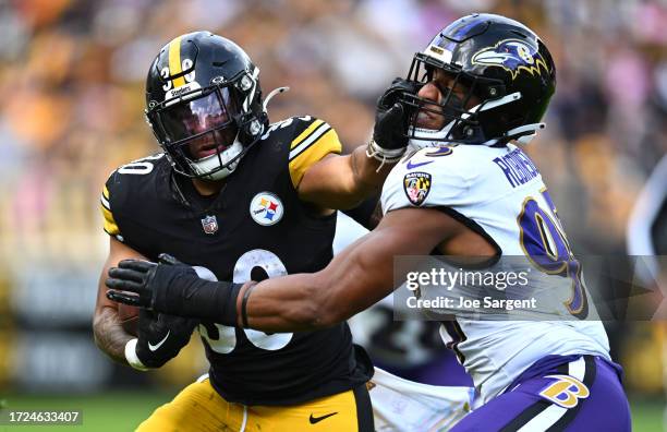 Jaylen Warren of the Pittsburgh Steelers stiff arms Tavius Robinson of the Baltimore Ravens during the third quarter at Acrisure Stadium on October...