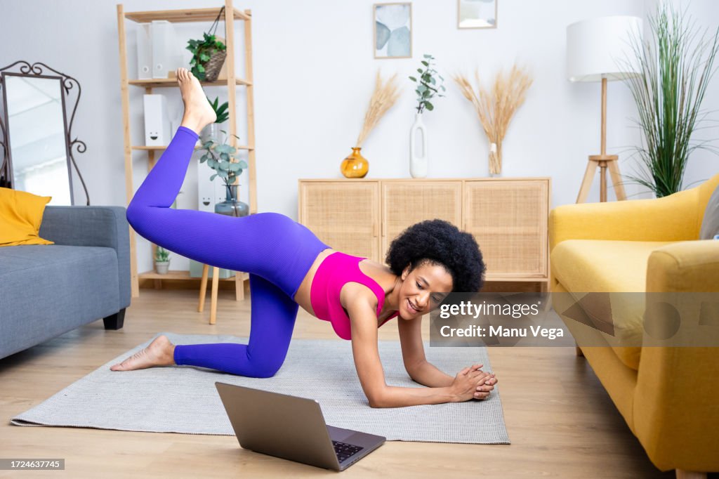 Cheerful black woman doing plank exercise