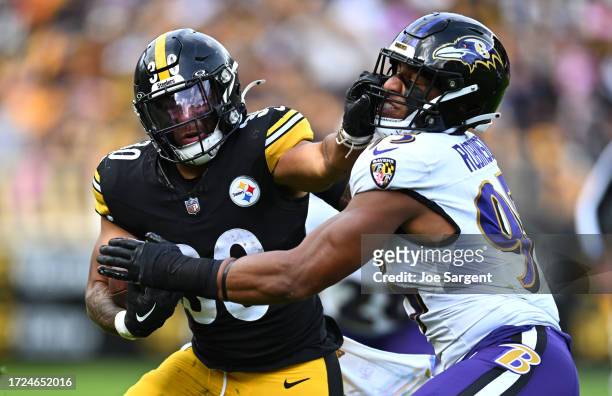 Jaylen Warren of the Pittsburgh Steelers stiff arms Tavius Robinson of the Baltimore Ravens during the fourth quarter at Acrisure Stadium on October...