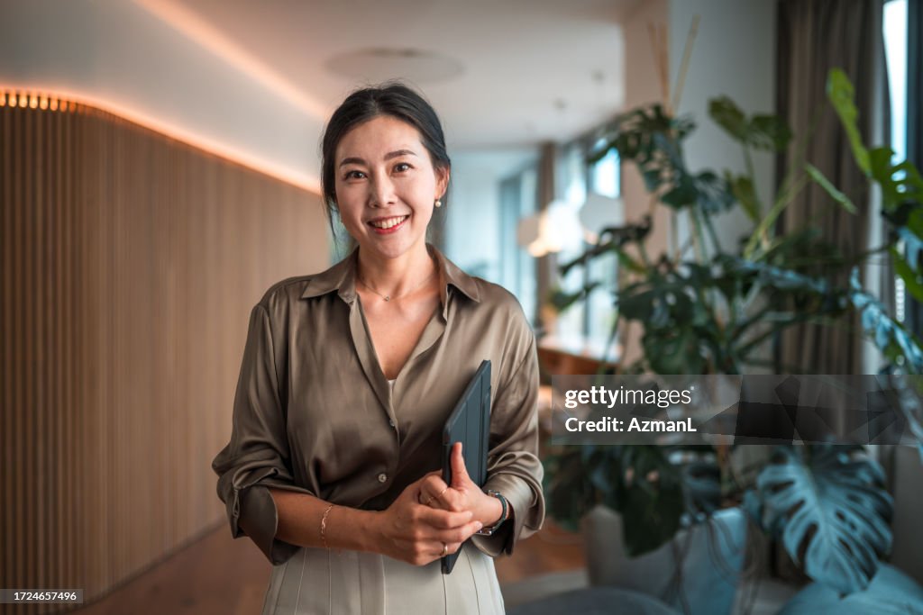 Funcionária corporativa coreana sorridente com dispositivo digital