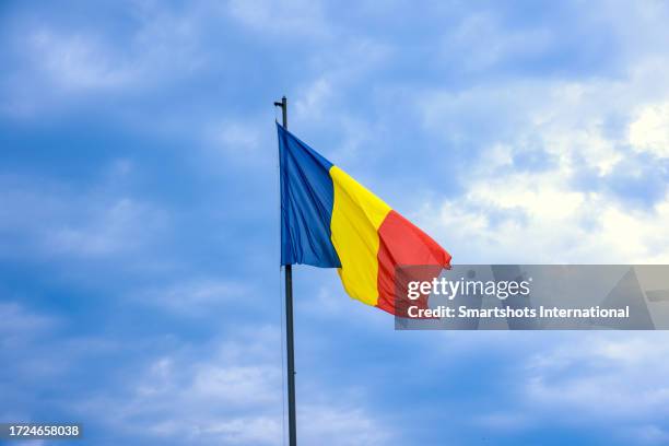 national flag of romania against dramatic sky in bucharest, romania - bandeira da roménia imagens e fotografias de stock
