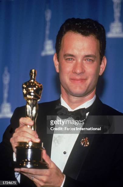 American actor Tom Hanks holds up the Oscar statuette he won for Best Actor for his role in the film, 'Philadelphia,' Academy Awards, Dorothy...