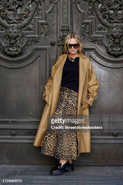 Influencer Tamara von Nayhauss, wearing a beige trench coat by Maison Common, a gold and black leoprinted skirt by Maison Common, a dark blue...