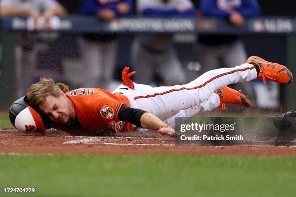 Gunnar Henderson of the Baltimore Orioles slides into home plate to score against the Texas Rangers during the first inning in Game Two of the...