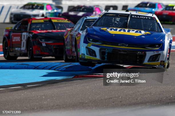 Chase Elliott, driver of the NAPA Auto Parts Chevrolet, and Kyle Busch, driver of the Lenovo Chevrolet, race during the NASCAR Cup Series Bank of...