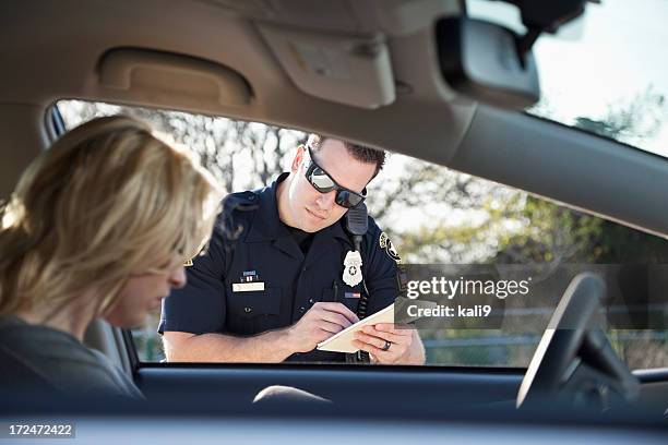 police officer writing ticket - verkeerspolitie stockfoto's en -beelden