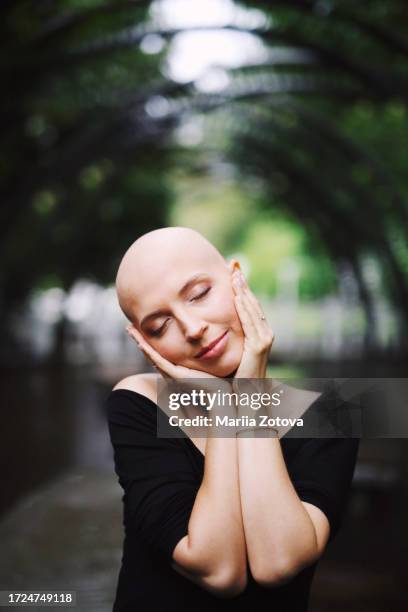 portrait of a young girl with her eyes closed in close-up, suffering from breast cancer or baldness. victory over the disease cancer - female head no hair stock-fotos und bilder