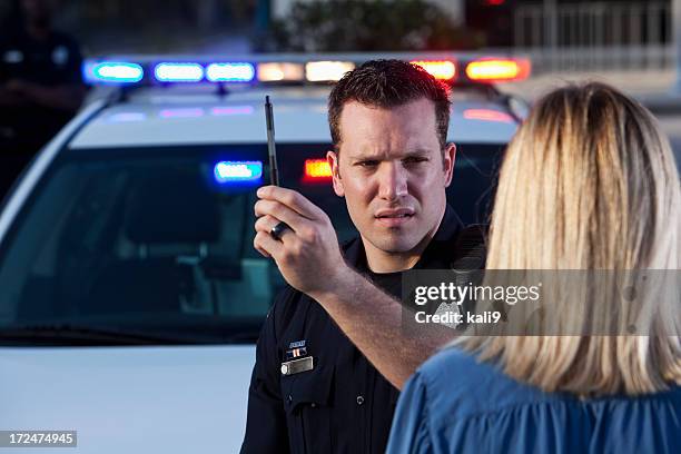 police officer conducting sobriety test - back of womens heads stockfoto's en -beelden