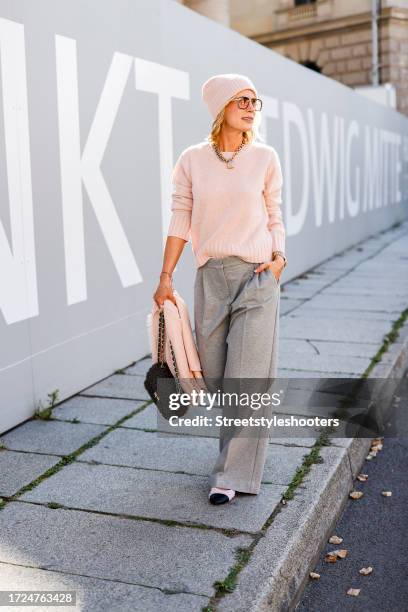 Influencer Tamara von Nayhauss, wearing light grey pants with wide legs by The Mercer, a rose cashmere pullover by The Mercer, a rose caschmere cap...