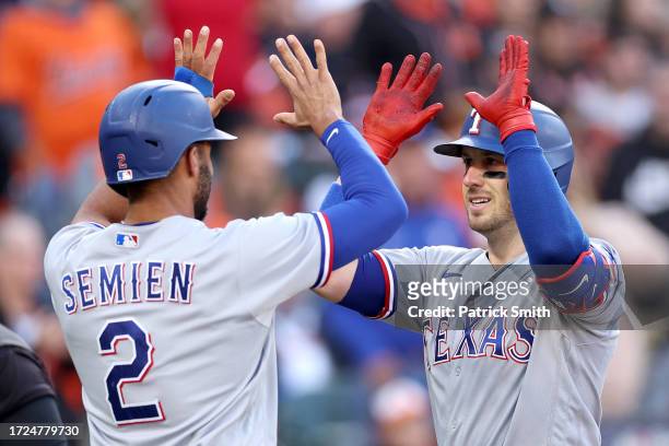 Mitch Garver of the Texas Rangers celebrates his grand slam with Marcus Semien against the Baltimore Orioles during the third inning in Game Two of...
