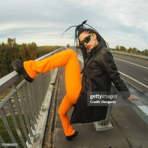 woman with dreadlocks in black coat on bridge. street style. - car attitude stock pictures, royalty-free photos & images